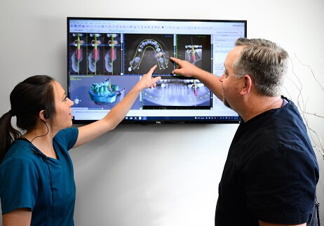 Dentists looking at 3 D C T cone beam scanner images