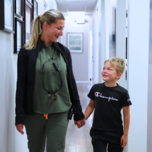 Dentist walking hand in hand with young child